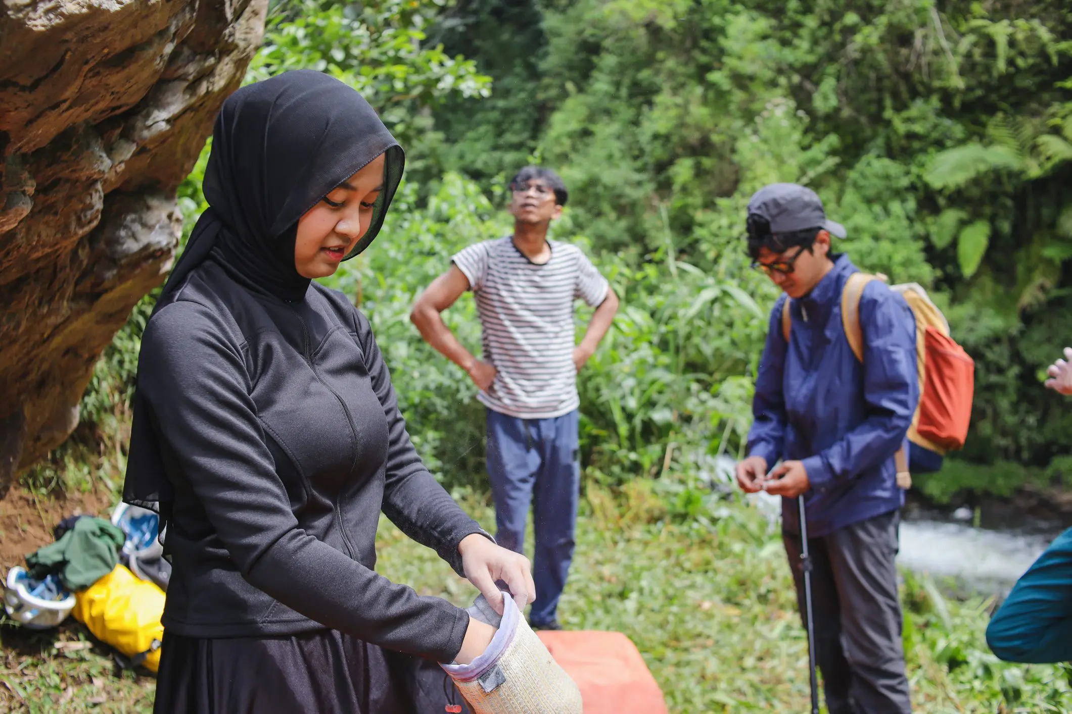 Group organizing gear by a rock